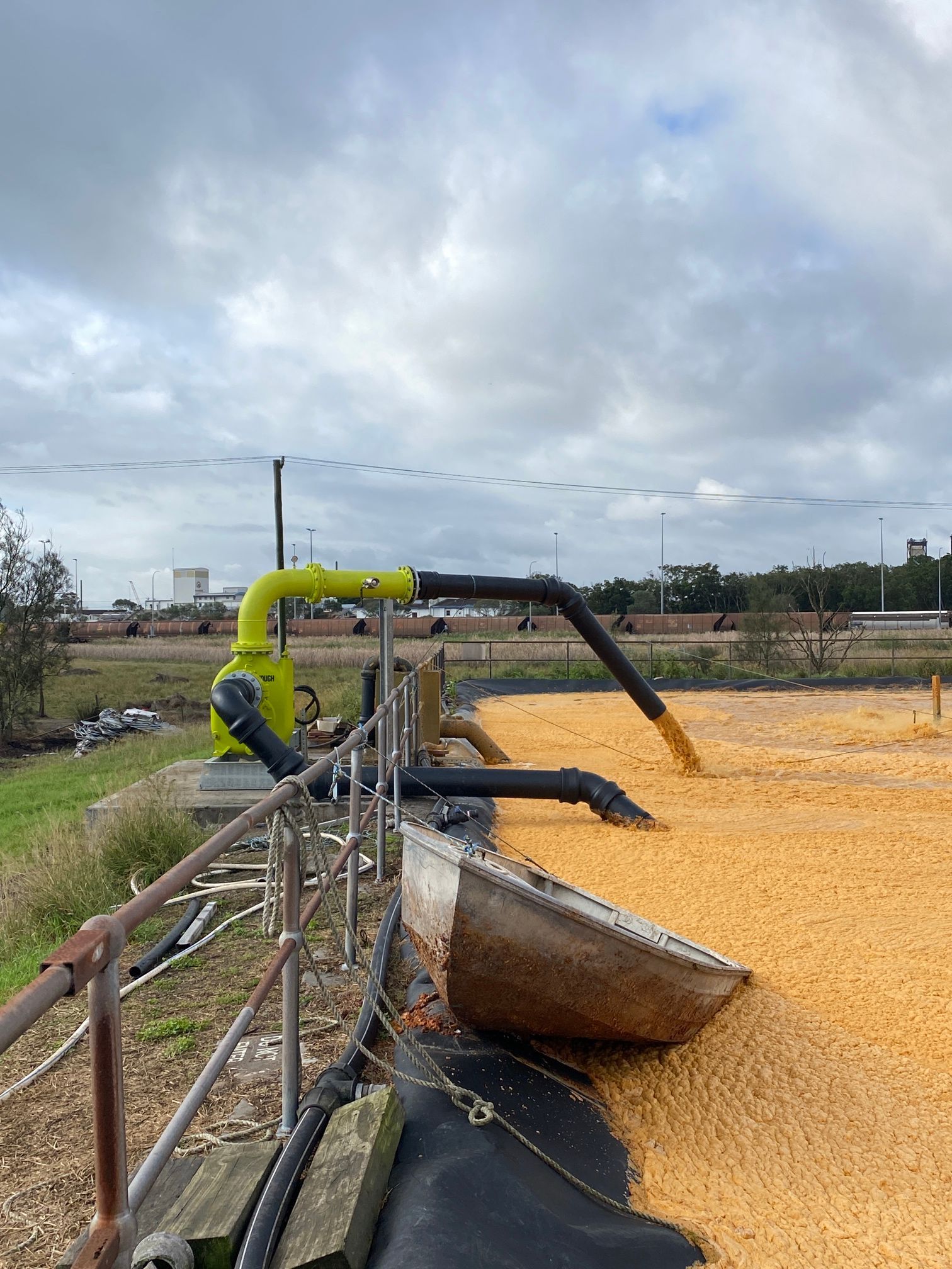 Worker operating a yellow pump hose — Huddo's Plumbing Service in Wallalong, NSW
