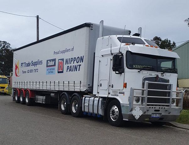 A White Semi Truck Is Parked On The Side Of The Road — PT Trade Supplies in Taree, NSW