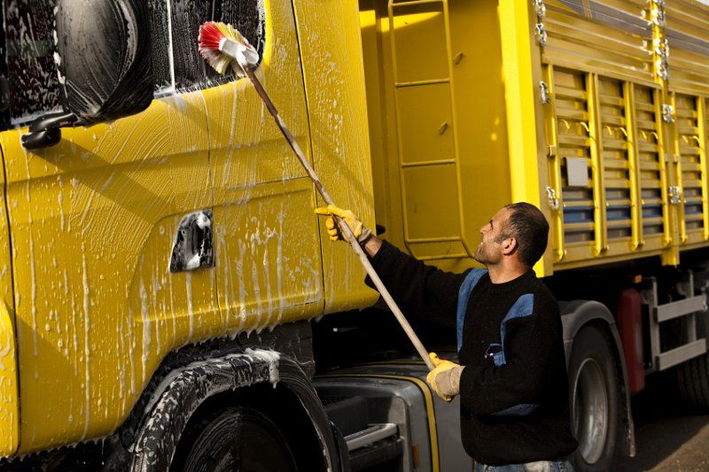 Worker Cleaning Exterior of Truck — Trade Supply Services in Taree, NSW