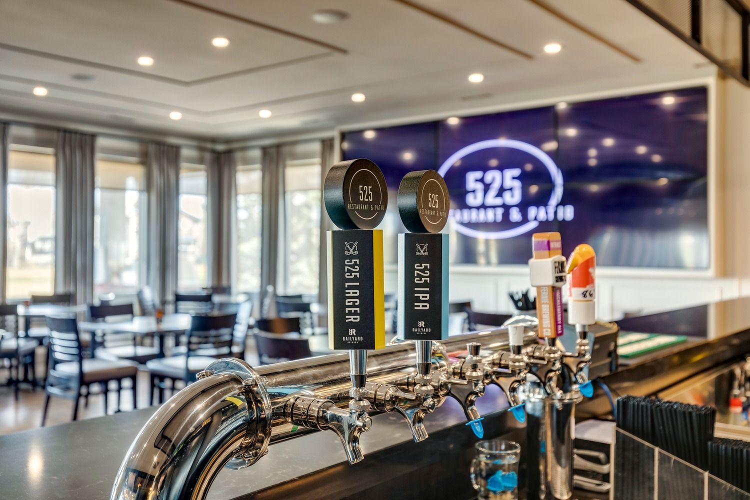 Beer taps on a bar counter in a restaurant setting with a 