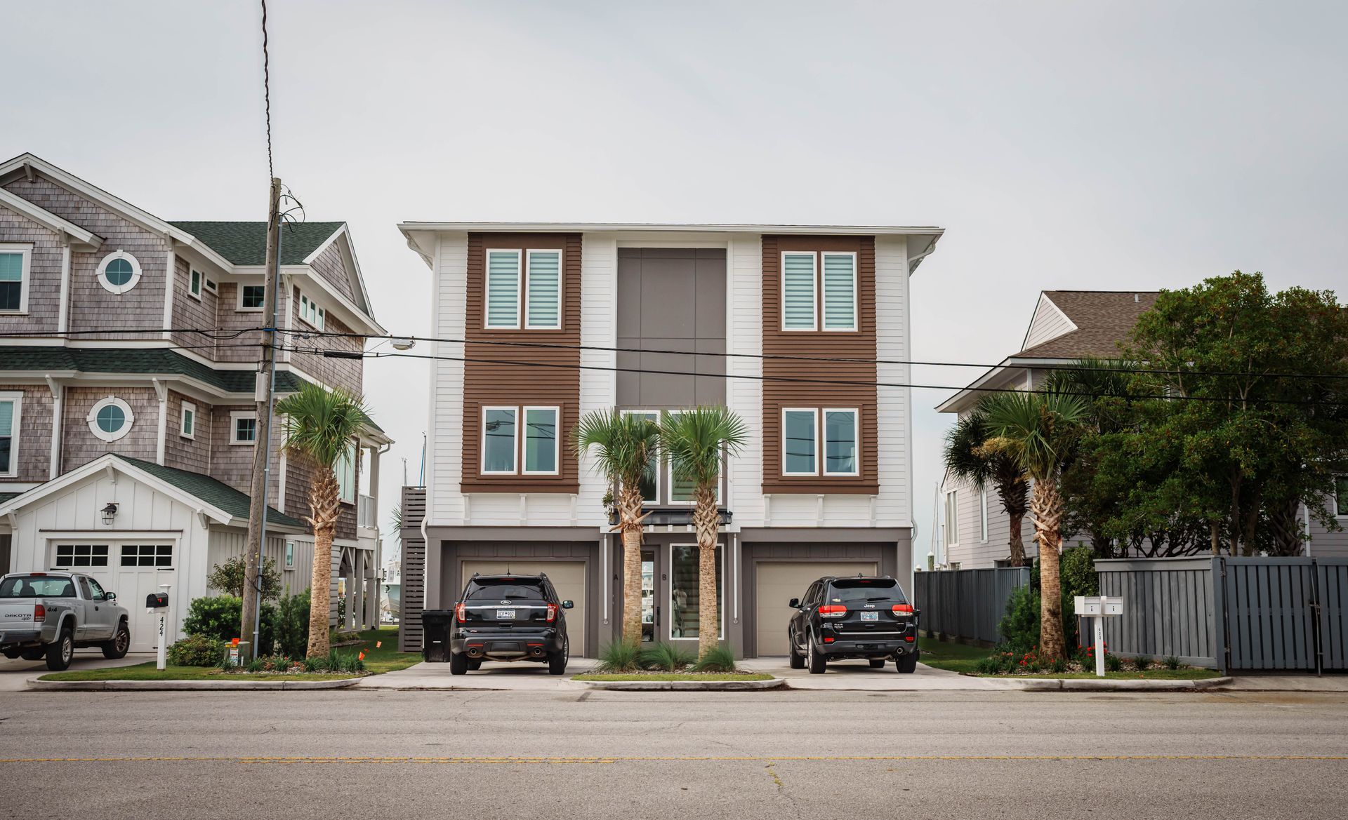A couple of cars are parked in front of a house