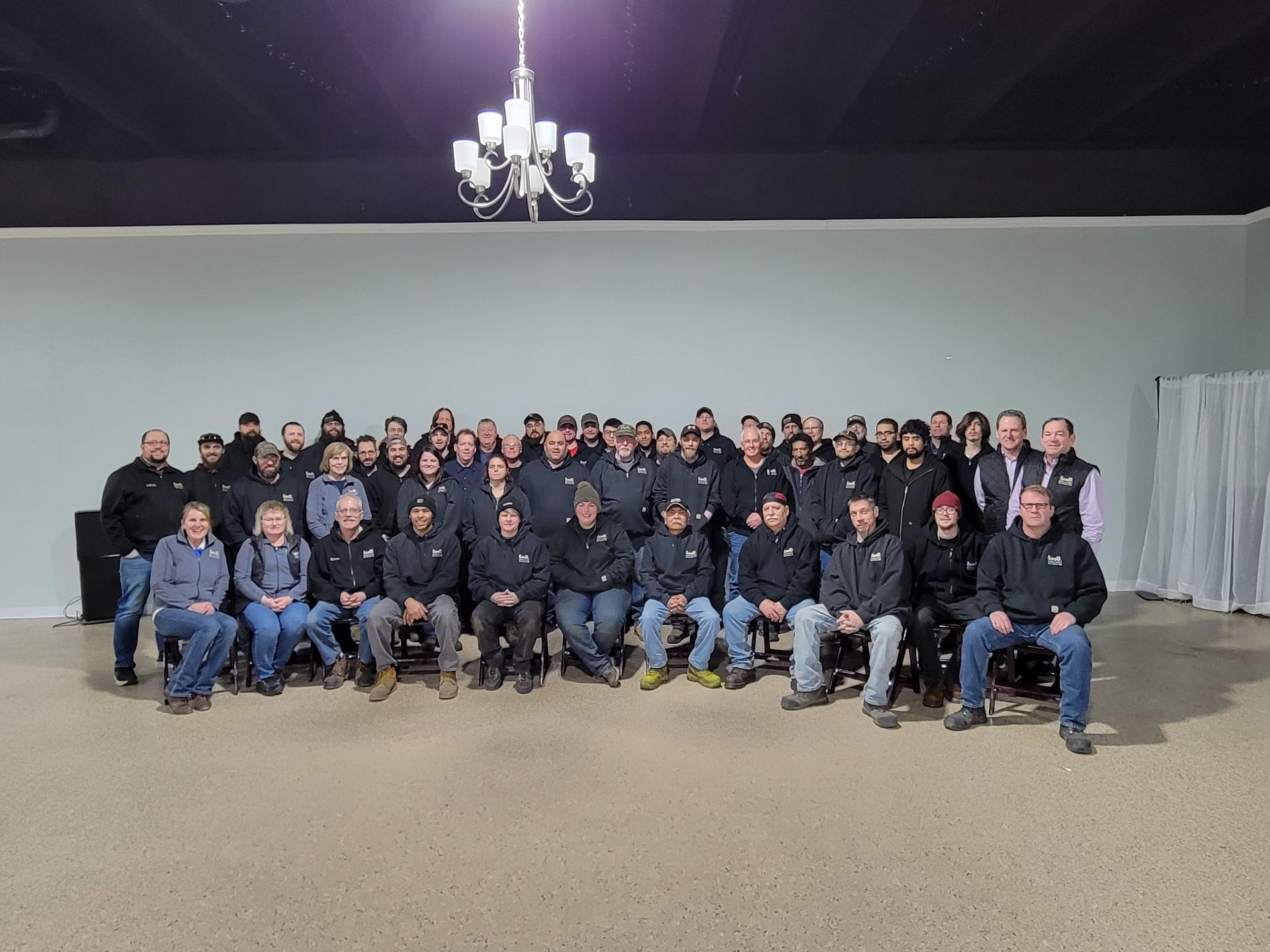 A large group of people are posing for a picture in a room.