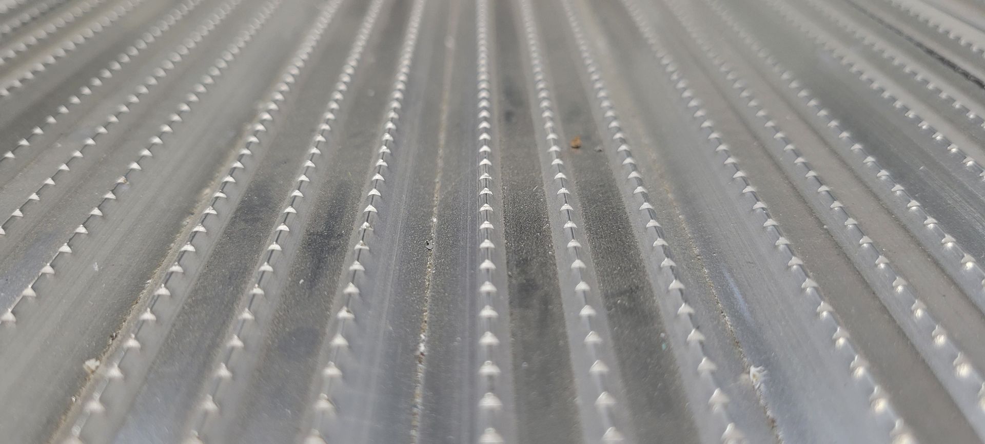A close up of a metal roof with holes in it.
