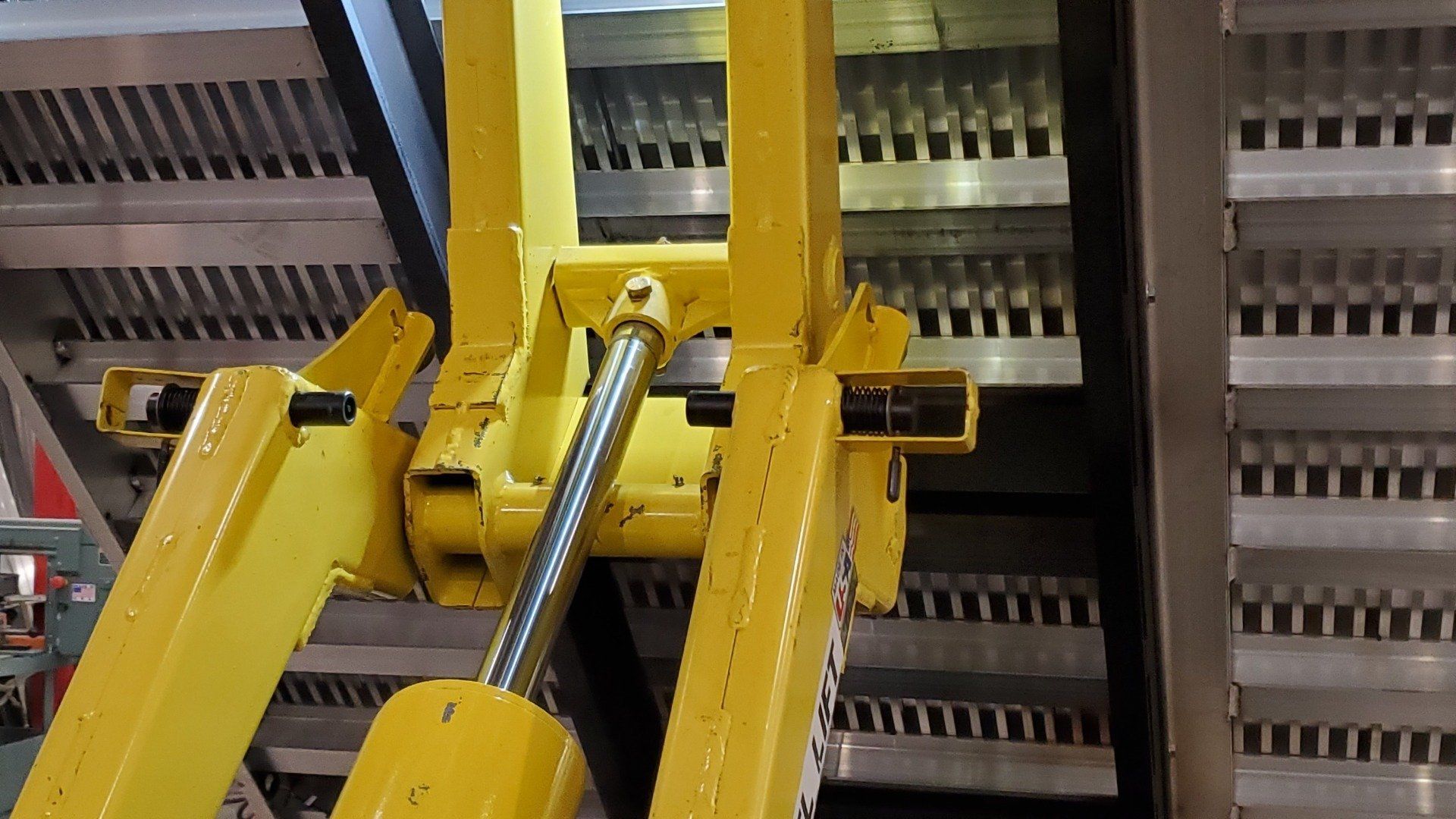 A yellow machine is sitting on top of a metal staircase.