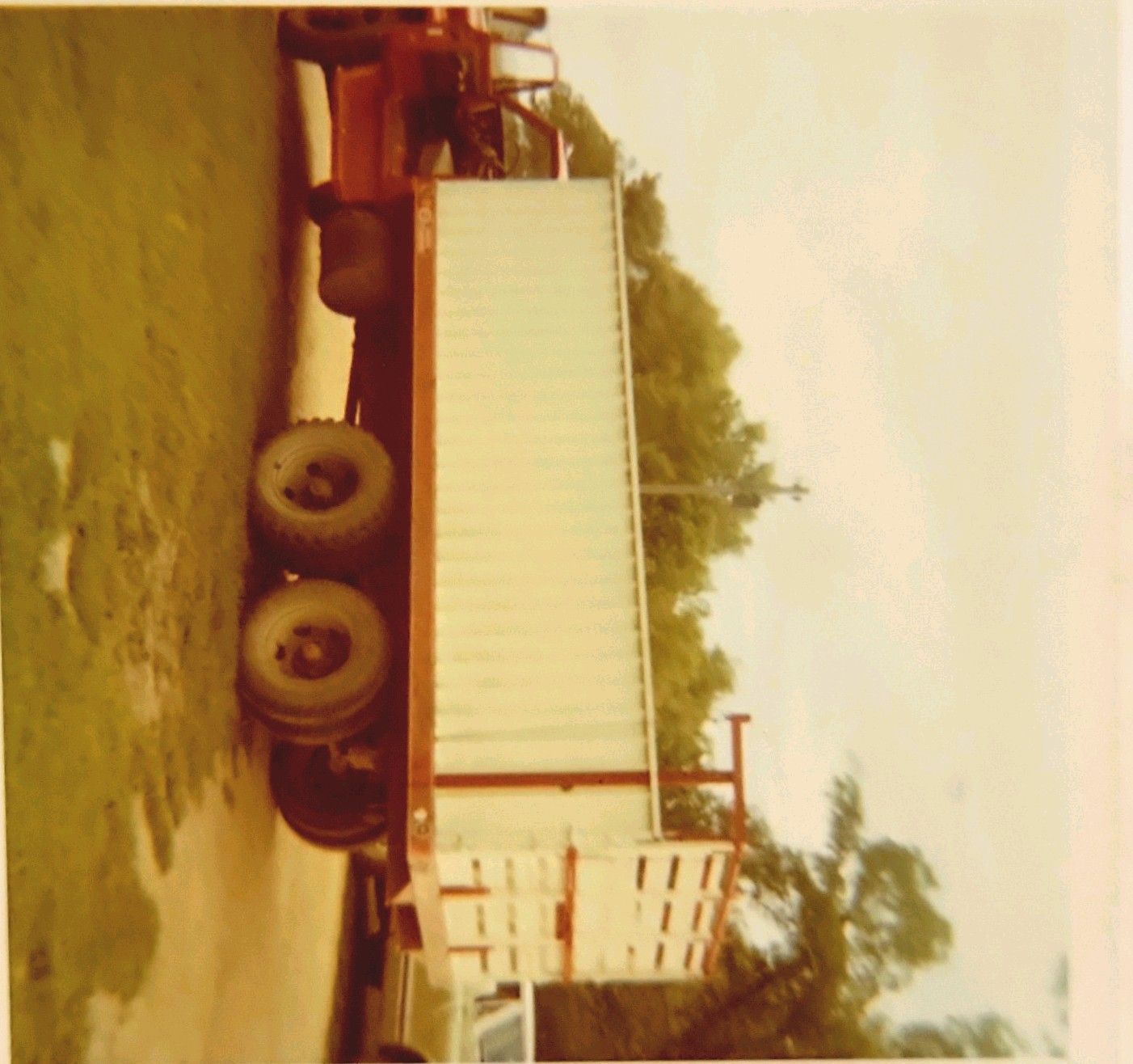 A red and white semi truck is parked on the side of the road