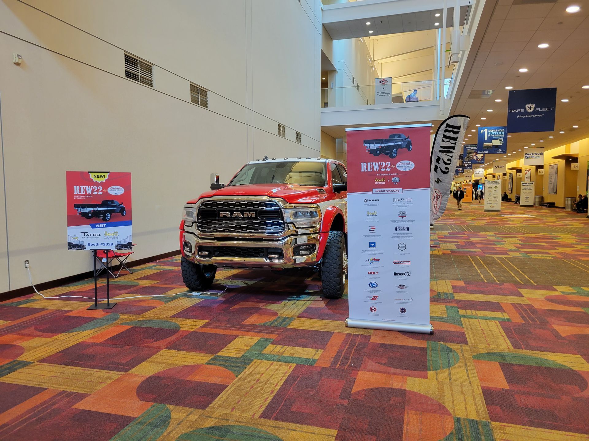 A red ram truck is parked in a hallway next to a sign.