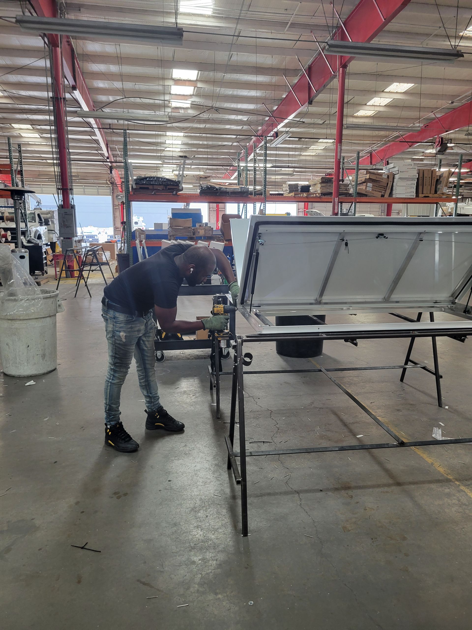 A man is working on a truck bed in a warehouse.