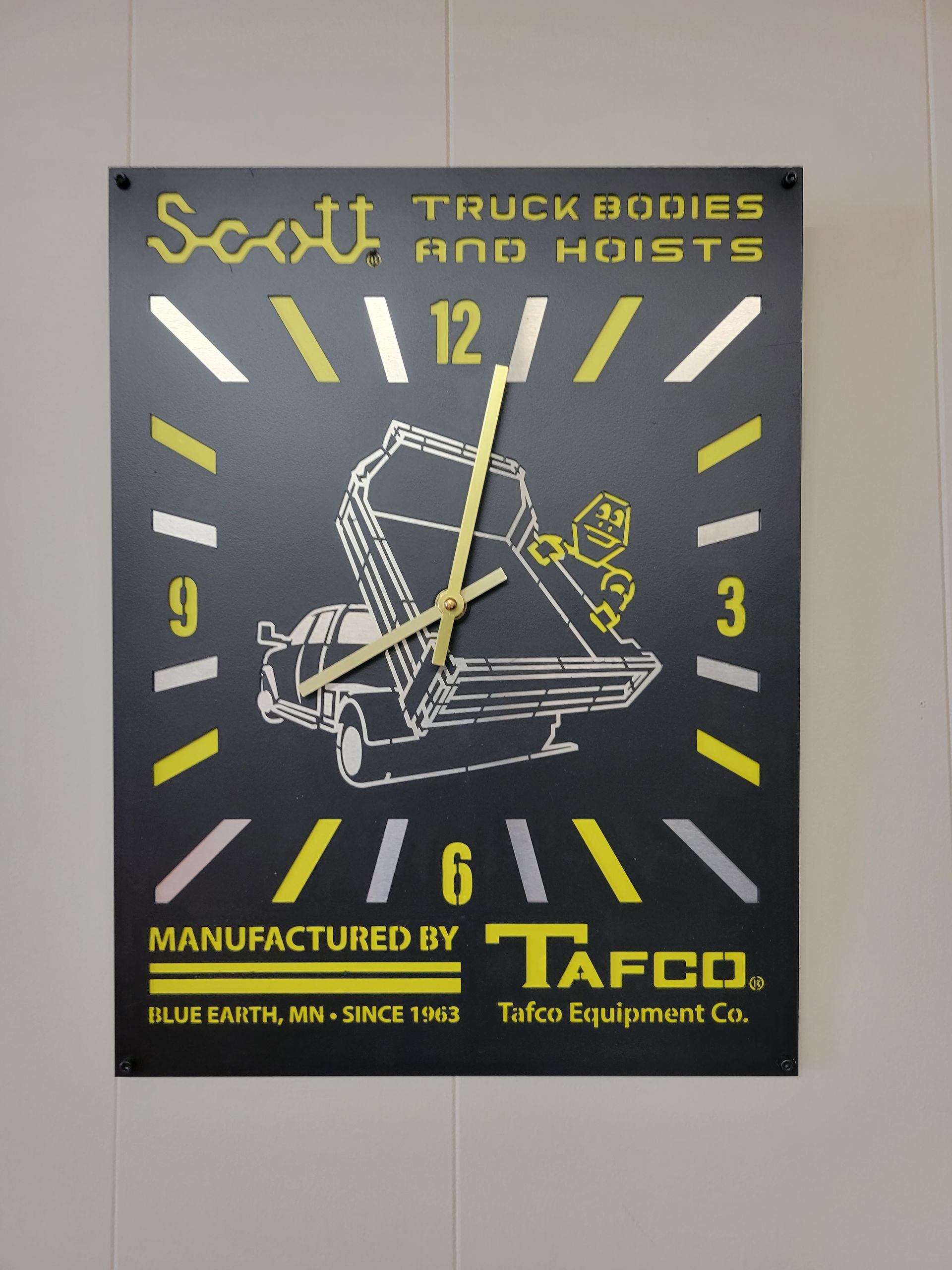 A clock that says ' scott truck bodies and hoists ' on it