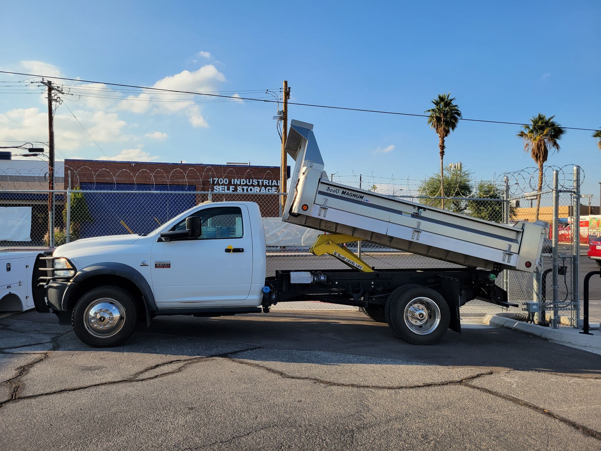 A white dump truck is parked on the side of the road.