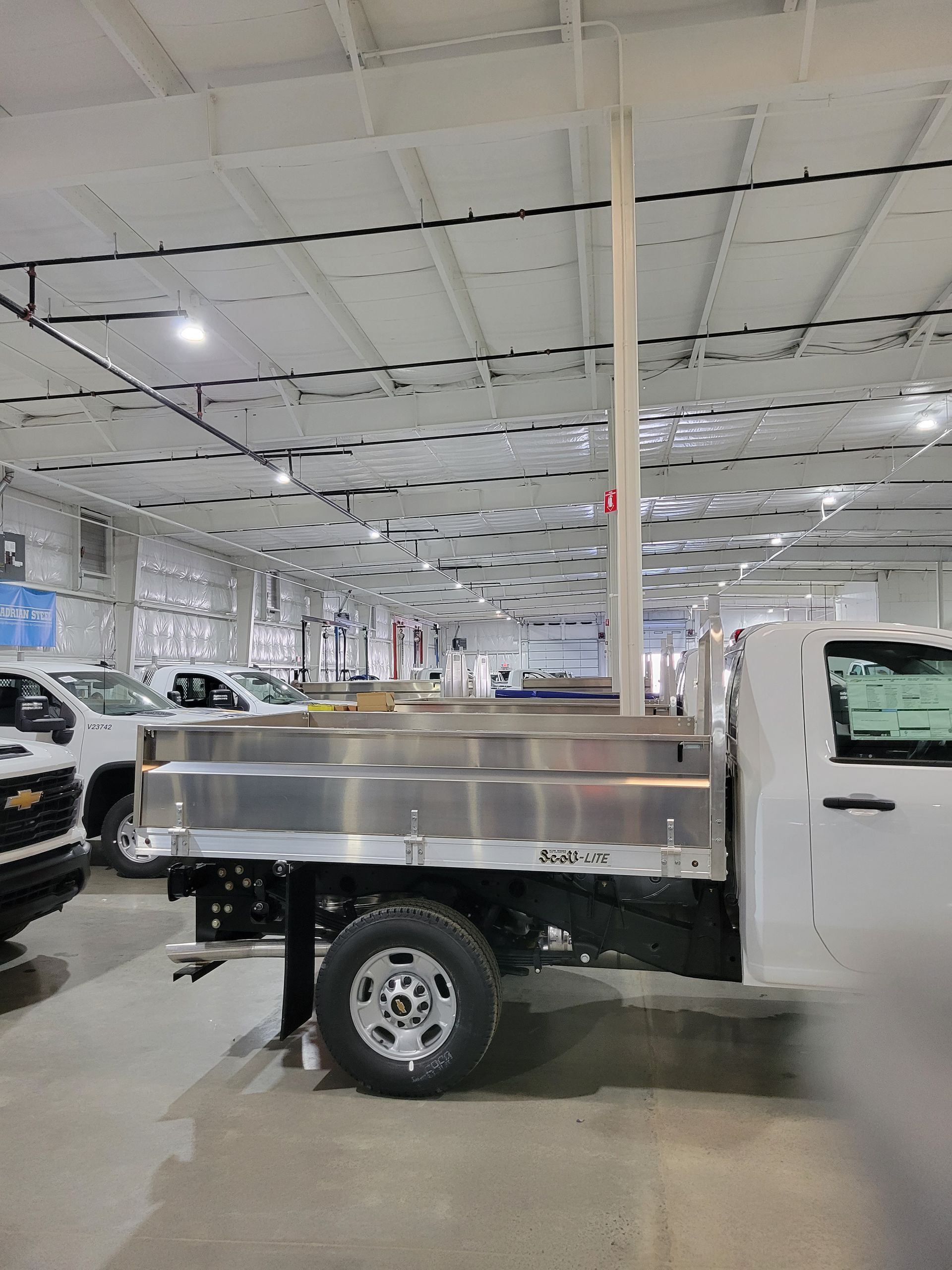 A white truck is parked in a large warehouse.