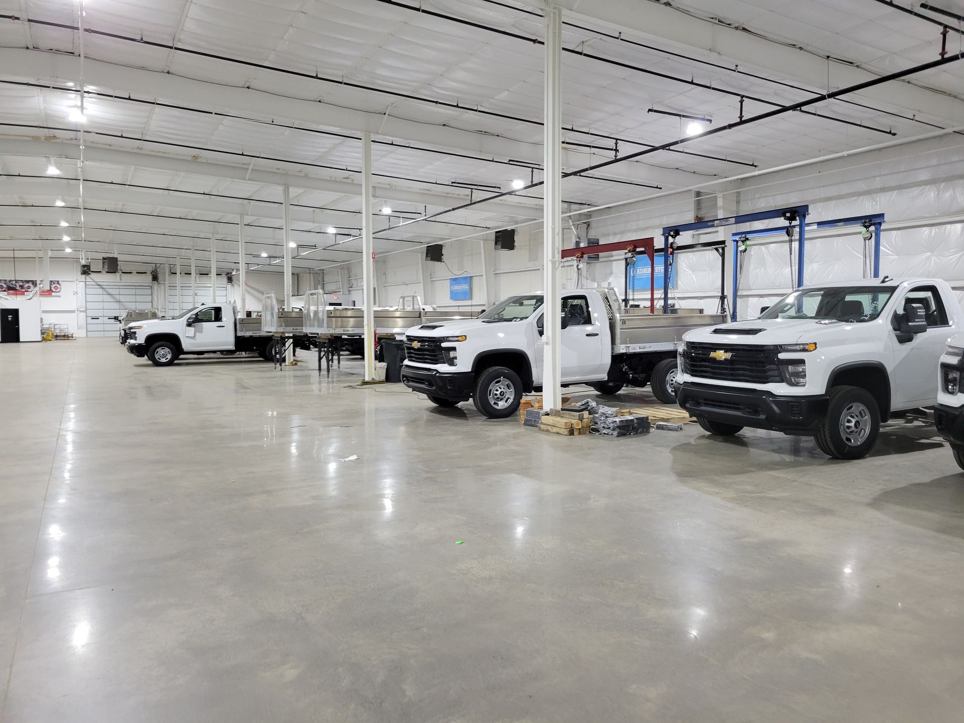 A row of trucks are parked in a large warehouse.