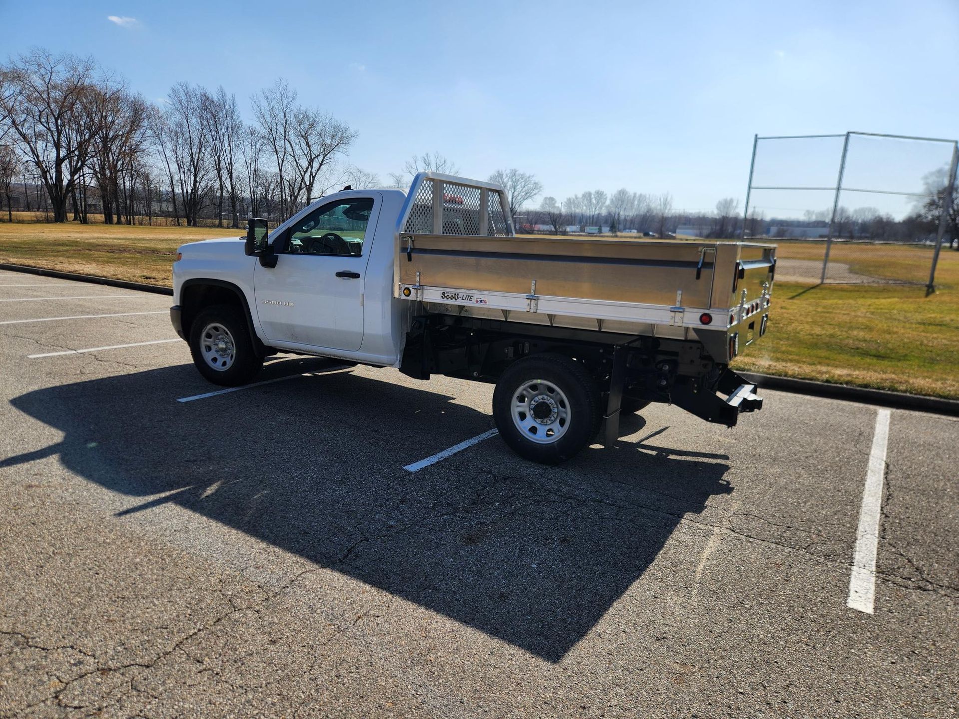 A white dump truck is parked in a parking lot.