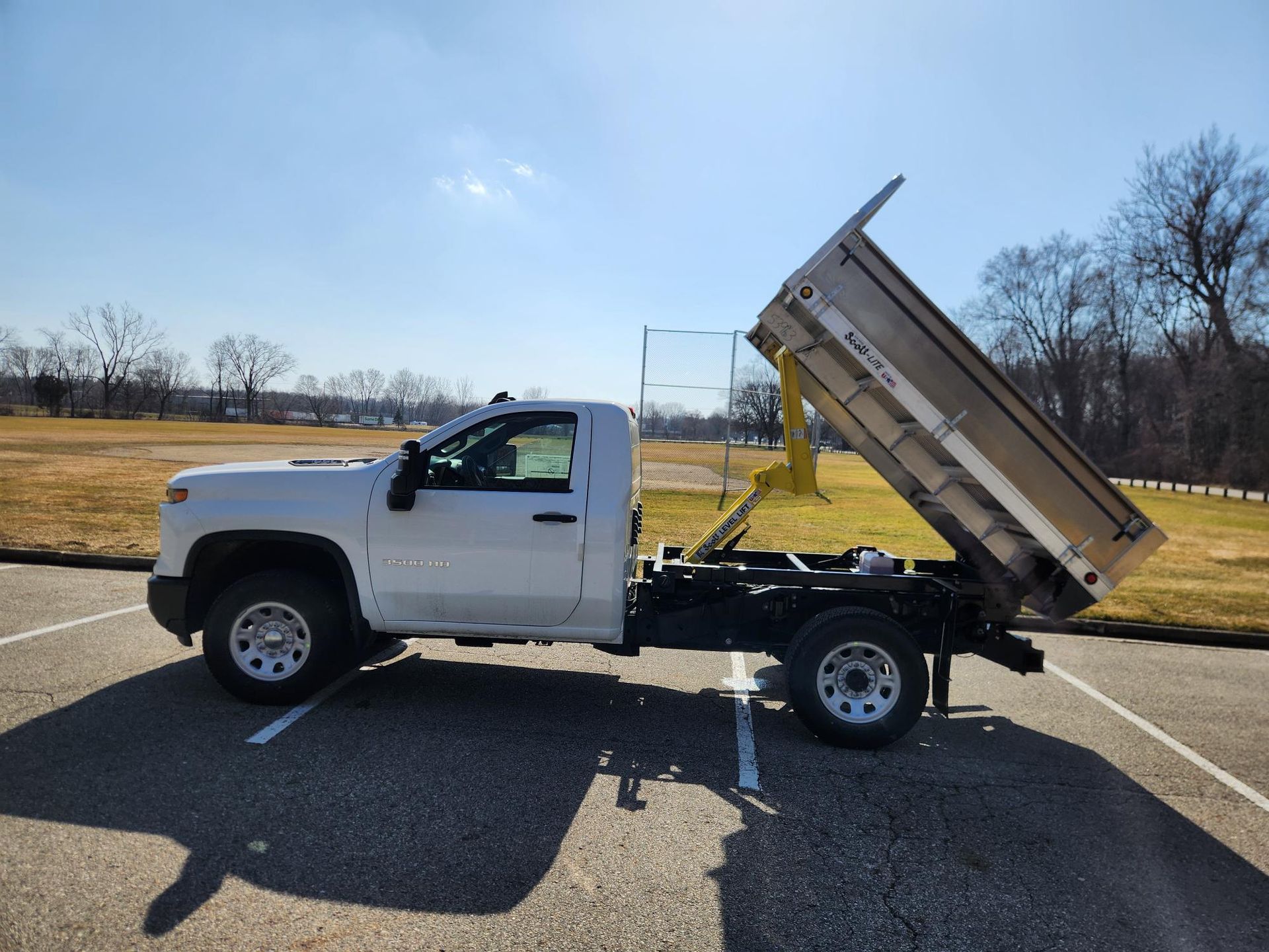 A white dump truck is parked in a parking lot.