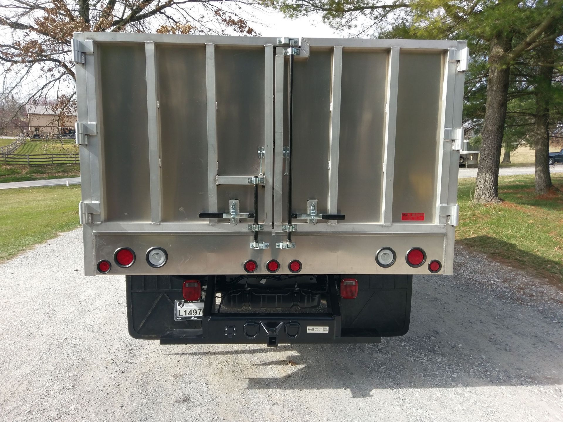 A dump truck is parked on a gravel road