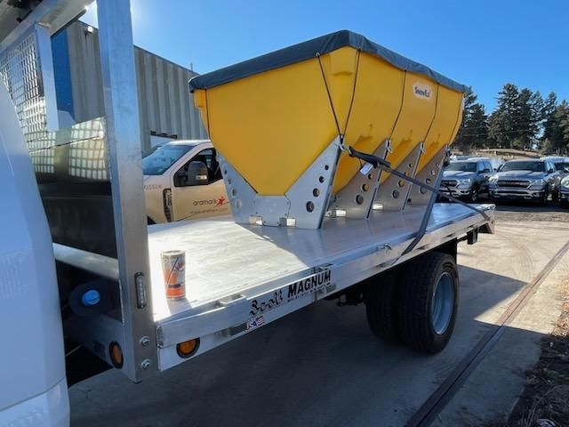 A white truck with a yellow container on the back of it