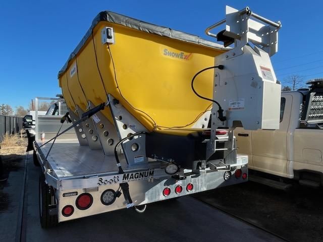 A white truck with a yellow trailer attached to it