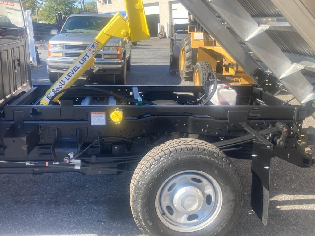 A dump truck with a yellow crane attached to it that says easy level lift