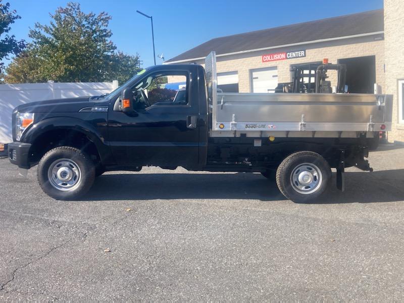 A black dump truck is parked in front of a building.