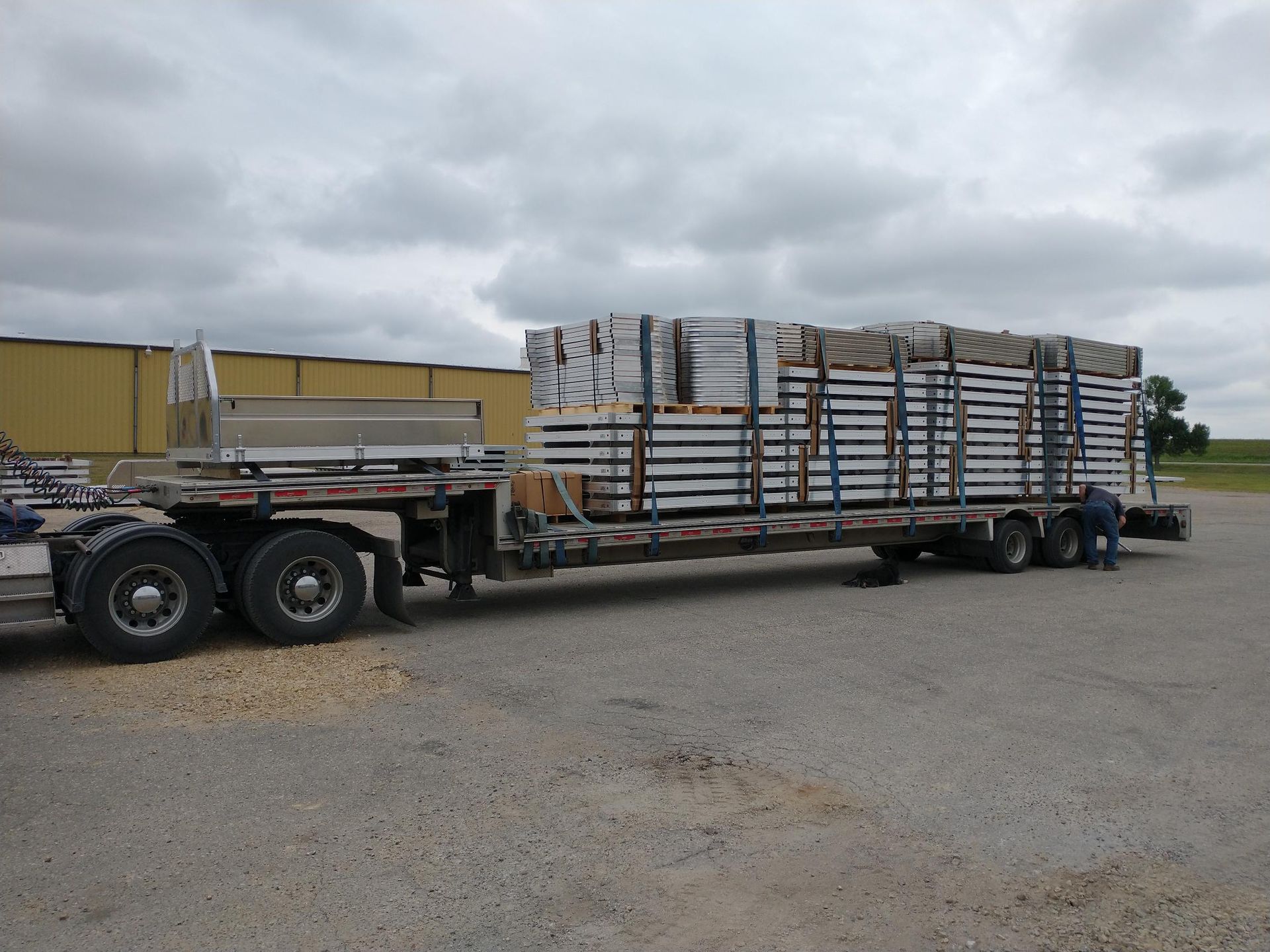 A semi truck is carrying a large stack of boxes