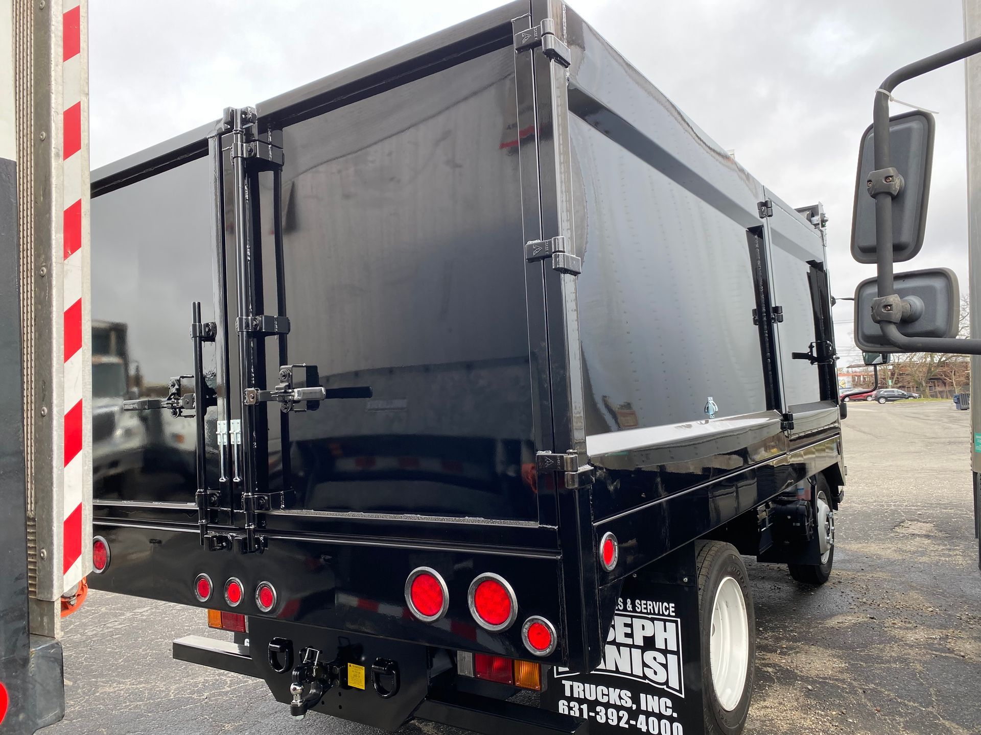 A black dump truck is parked in a parking lot.