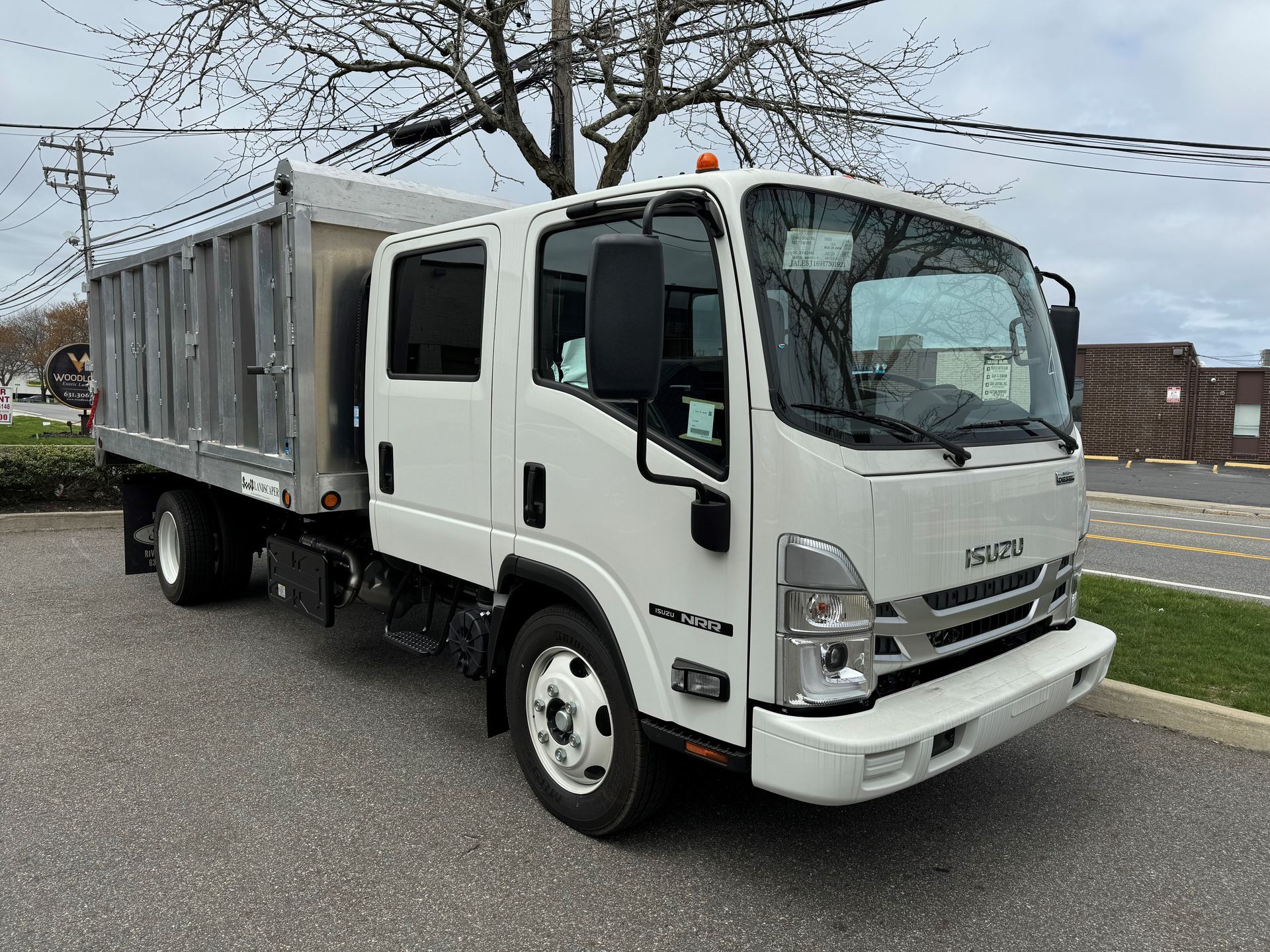 A white dump truck is parked on the side of the road.