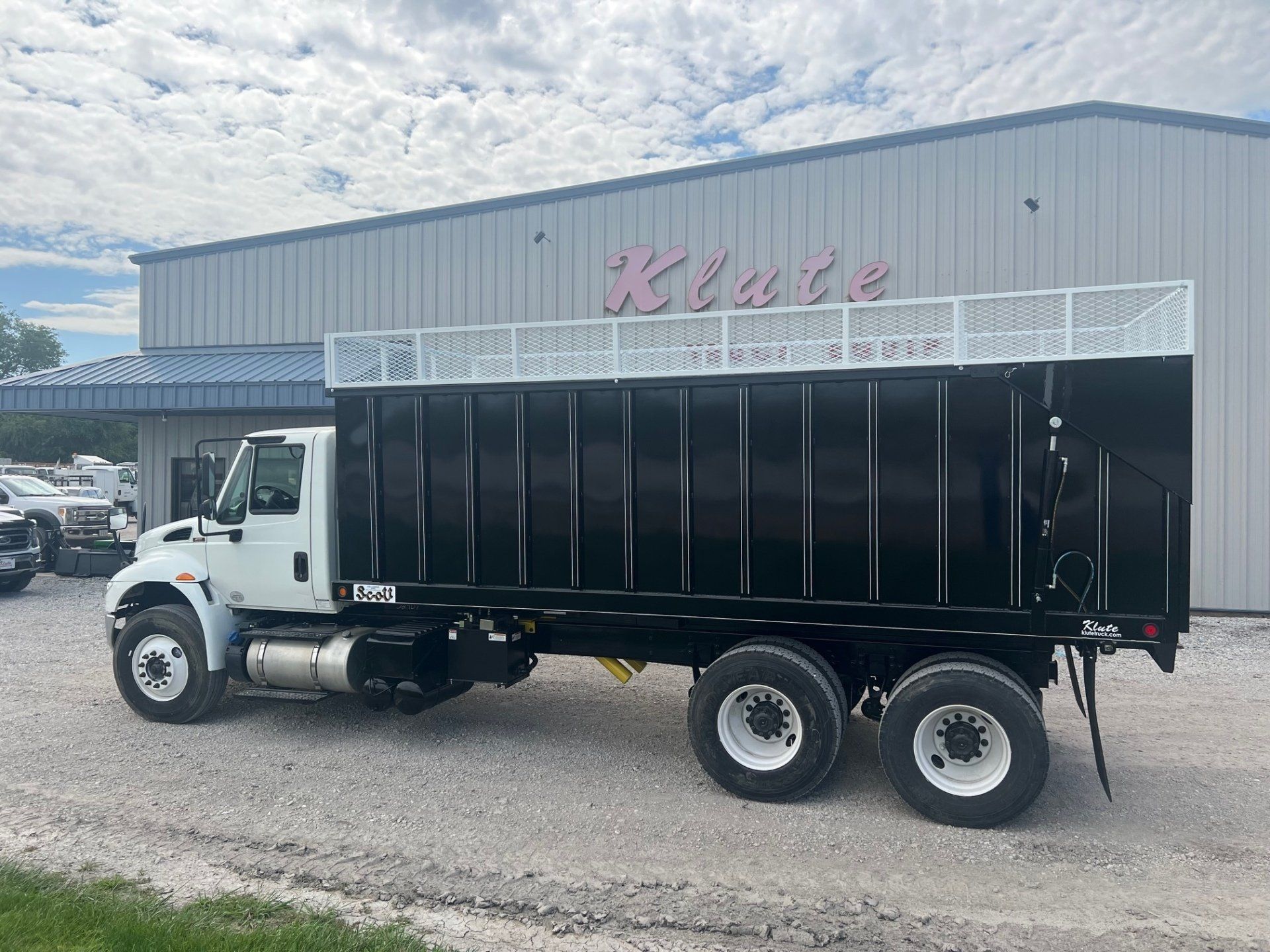 A dump truck is parked in front of a building.