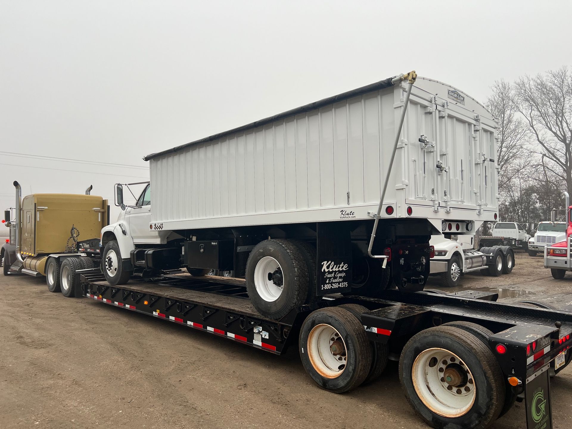 A semi truck with a trailer attached to it is parked in a parking lot.