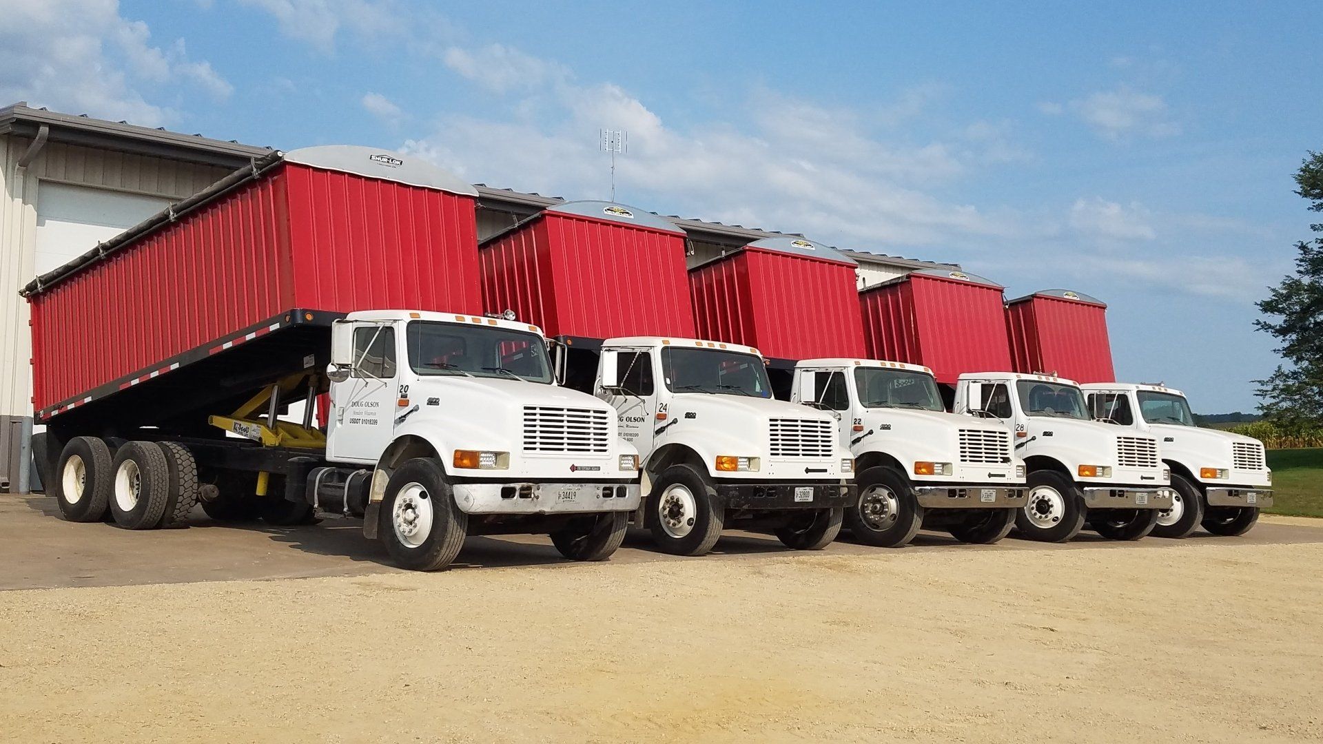 A row of white trucks parked next to each other