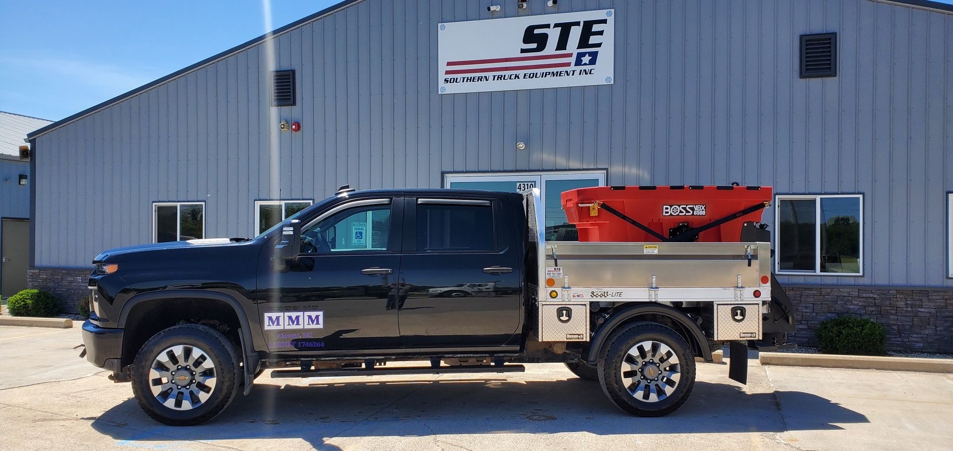A black truck is parked in front of a building.