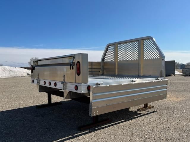 An aluminum truck bed is sitting on the ground in a parking lot.