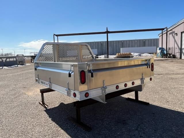 A stainless steel truck bed is sitting in a parking lot.