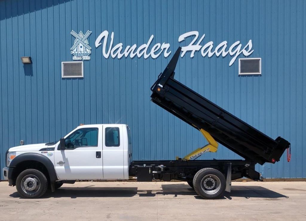 A dump truck is parked in front of a vander haags building