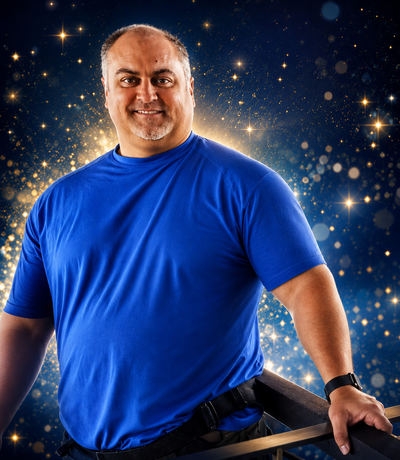 Person with curly hair holds sparkling glitter against a blue star-patterned background.