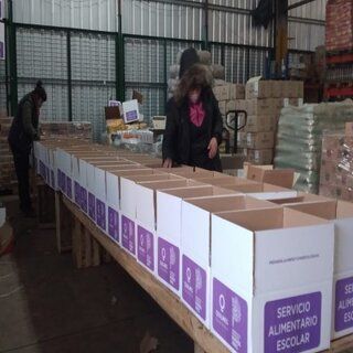 Dos personas empaquetan cajas con la etiqueta