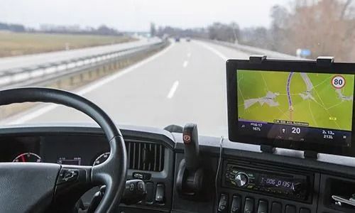 Vista del tablero de instrumentos de un automóvil con navegación GPS en una autopista a través de campo abierto.