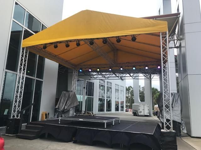 A stage with a yellow canopy and lights on it