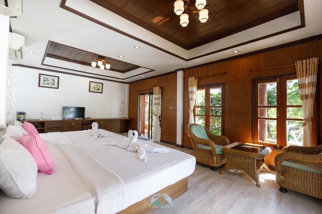 A hotel room with a large bed, seating area, and wooden accents.