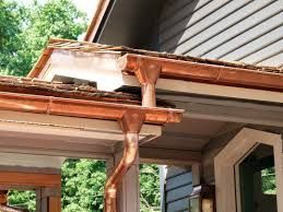A close up of a copper gutter on the side of a house.
