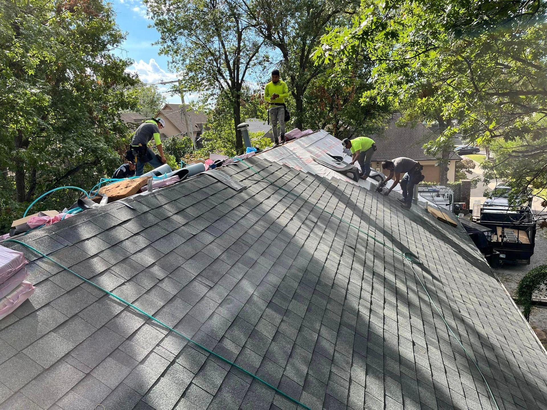 A group of men are working on the roof of a house.
