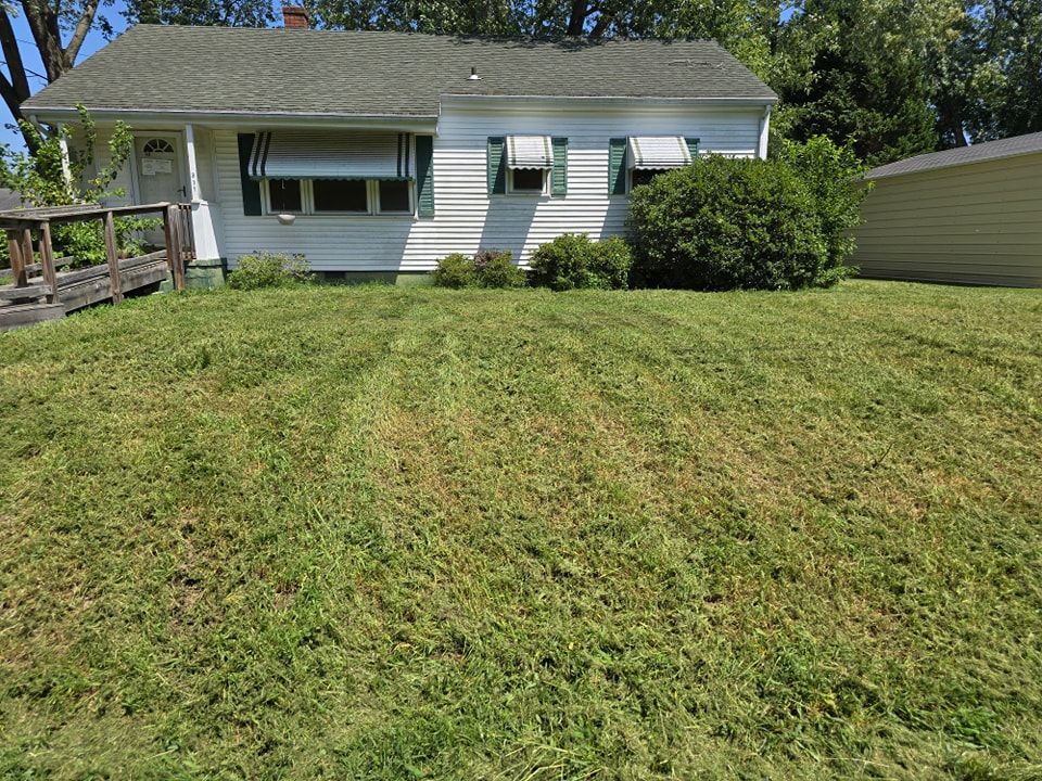 A white house with a lush green lawn in front of it.