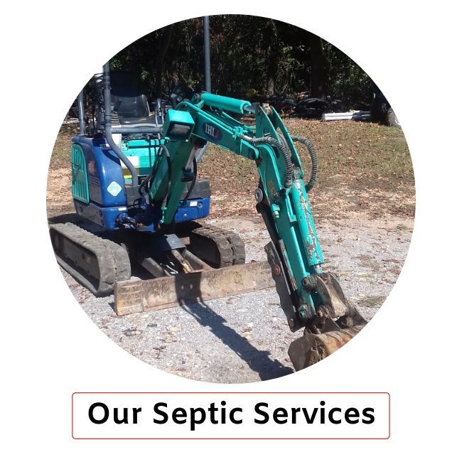 A teal mini excavator sits on a gravel lot next to a box labeled