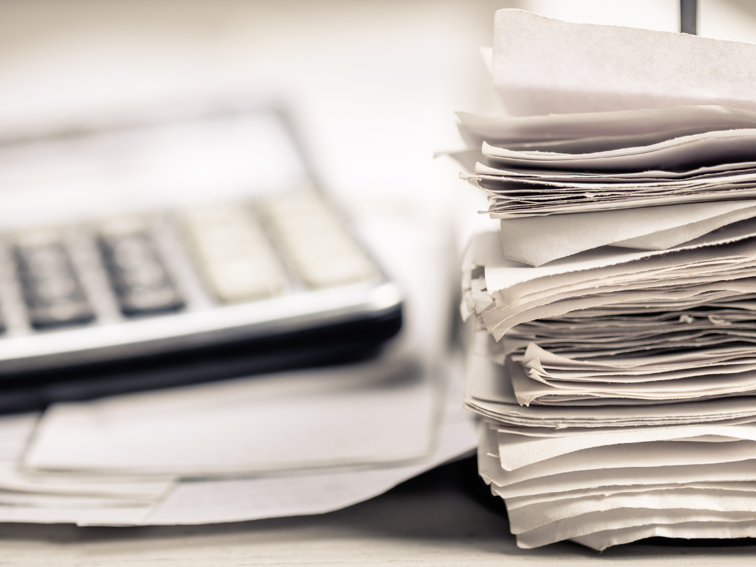 a pile of paperwork and a calculator
