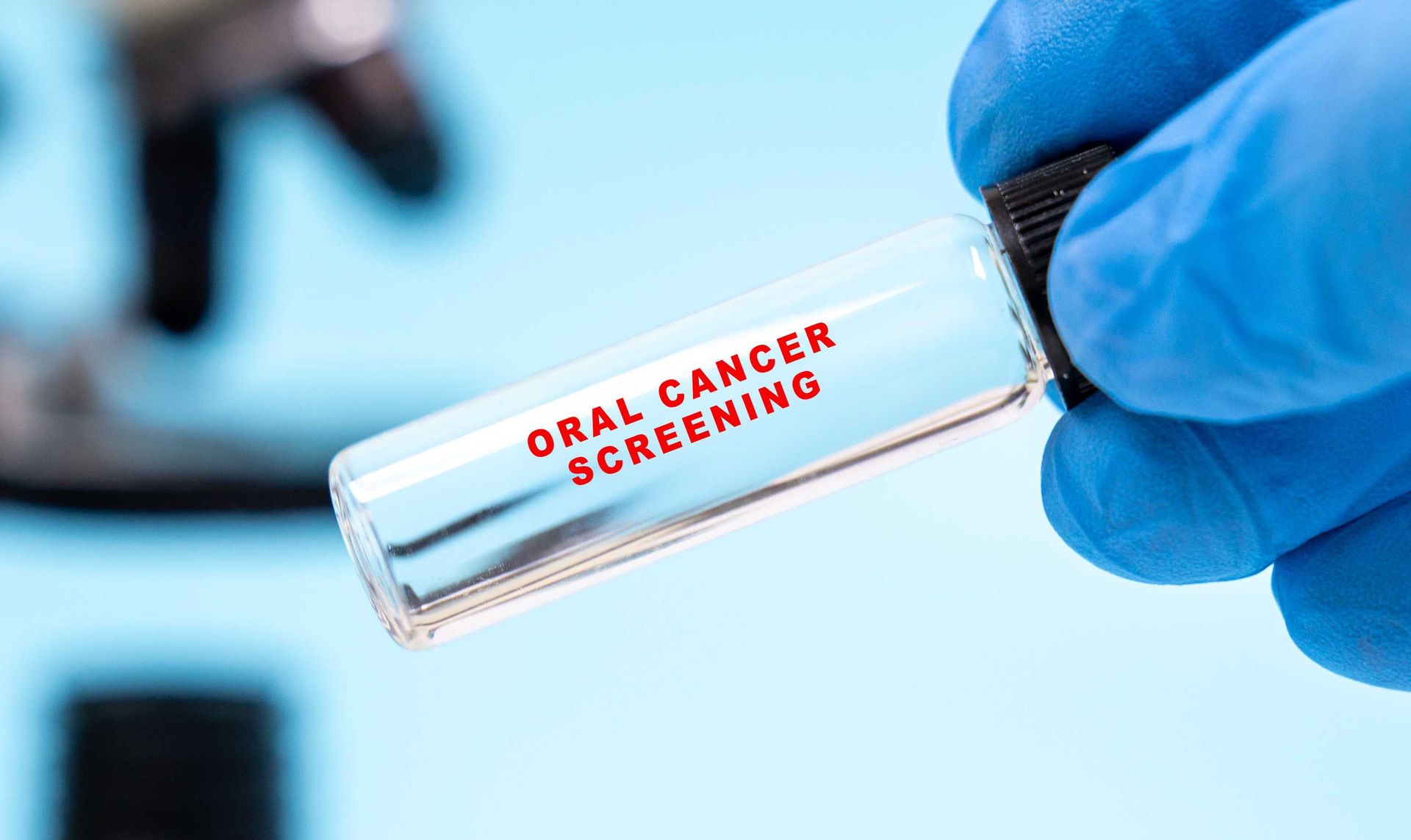Gloved hand holding a lab vial labeled for early detection Oral Cancer Screenings Gloved hand holding a lab vial labeled for early detection Oral Cancer Screenings