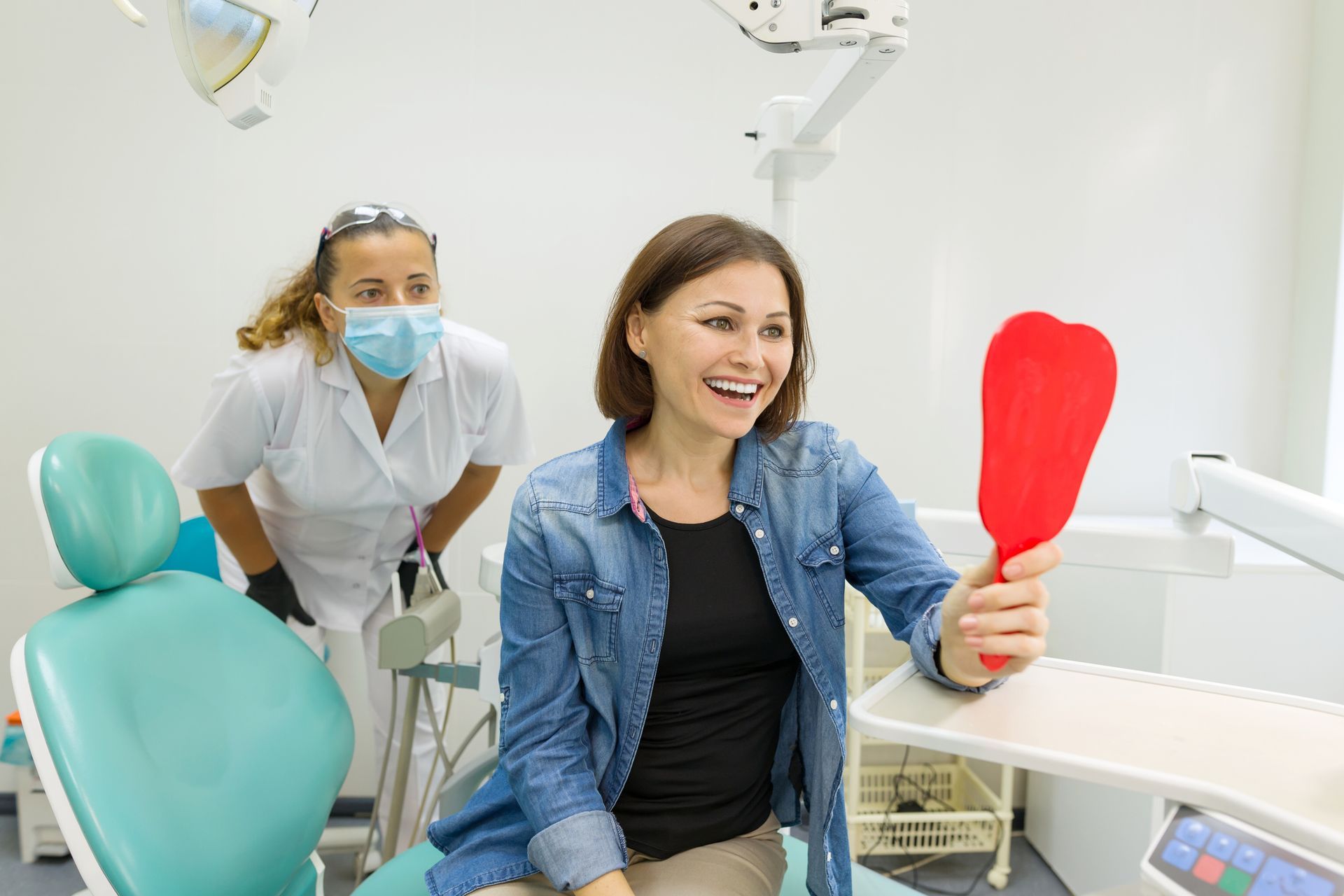 Dental patient checking smile in mirror during consultation at a modern dental office.