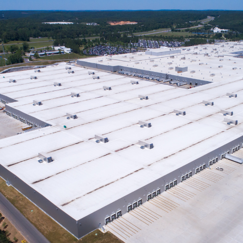 An aerial view of a large building with a white tpo roof