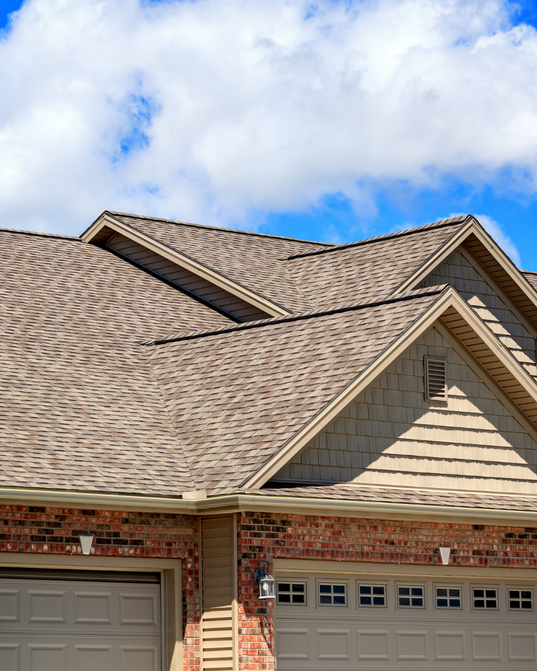 A house with a wood shingle roof and a garage door.