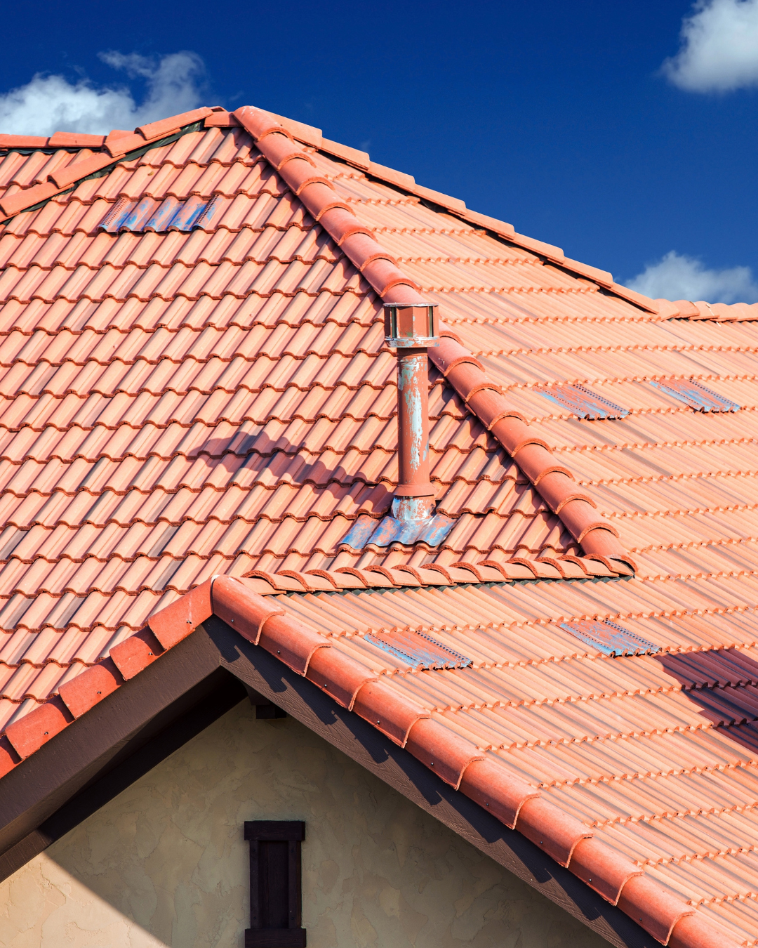 A red tiled roof with a chimney on top of it