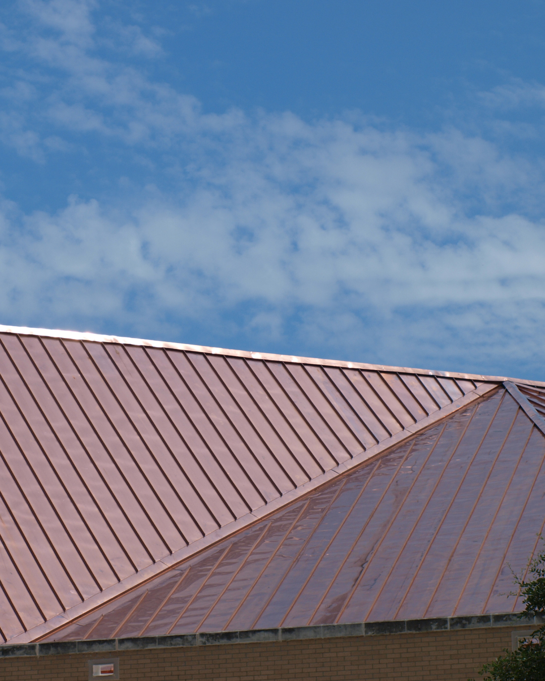 A copper roof with a blue sky in the background