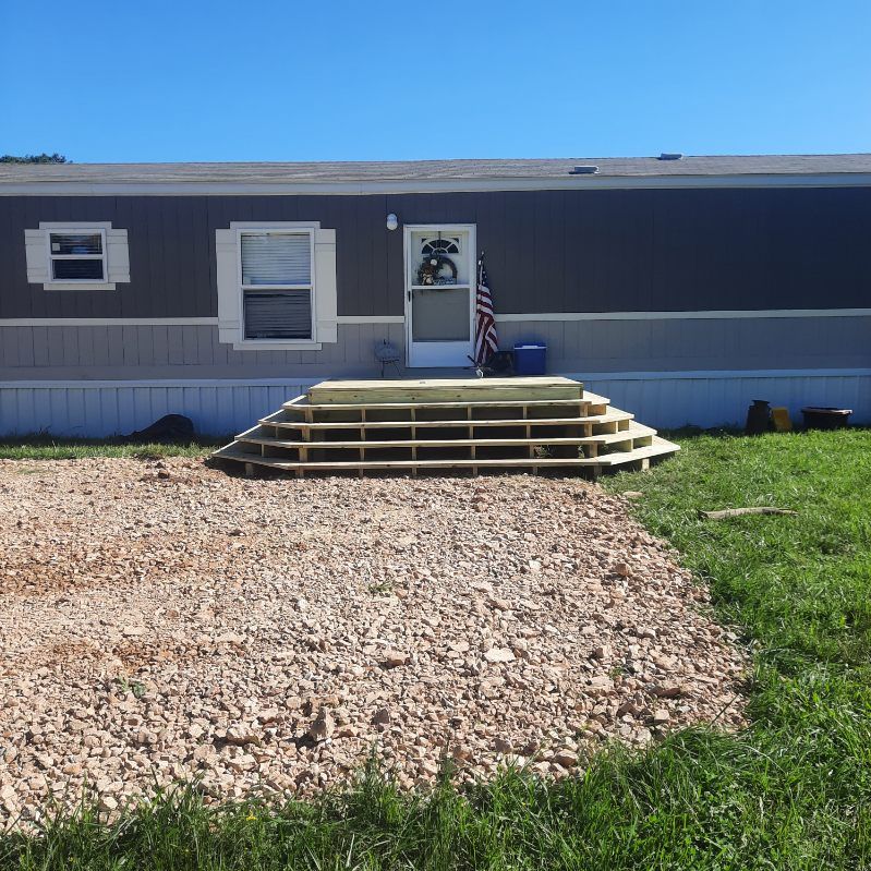 A mobile home with a wooden deck in front of it