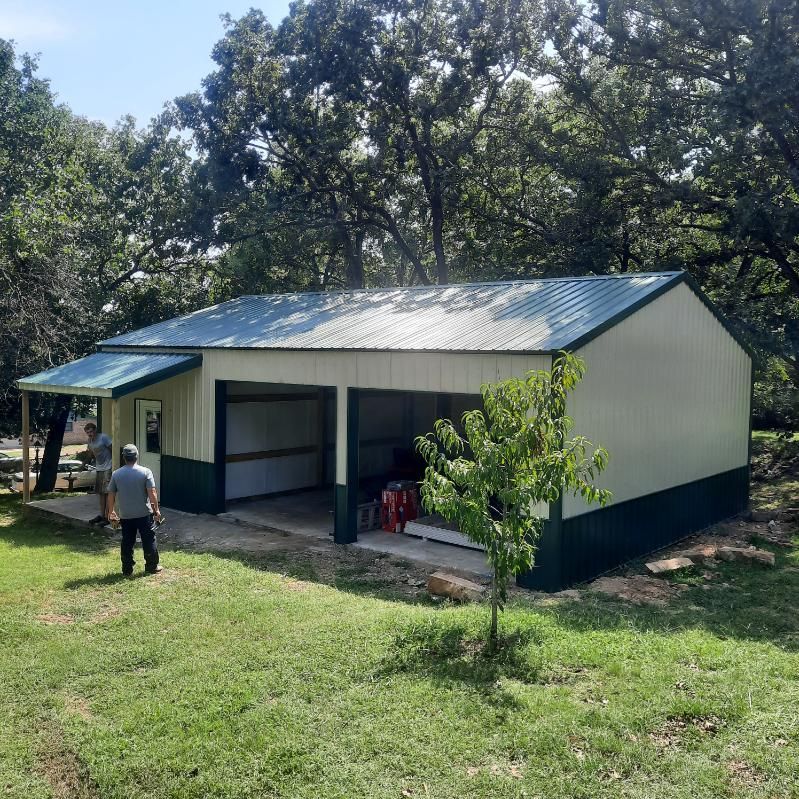 A man is standing in front of a white and green garage